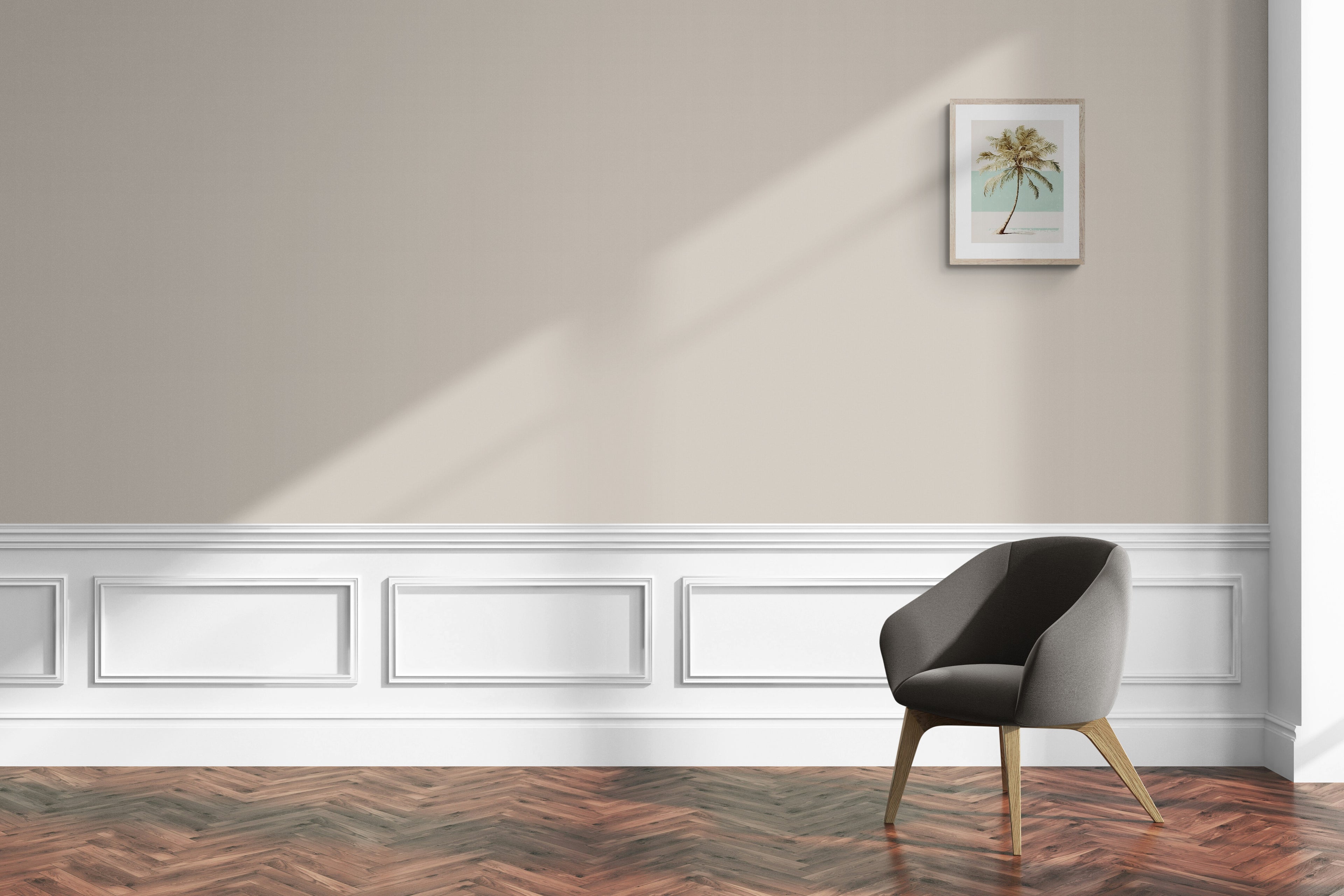 Comfy chair next to wall in Skimming Stone colour by Farow & Ball with a palm tree print in a wooden frame on the wall.